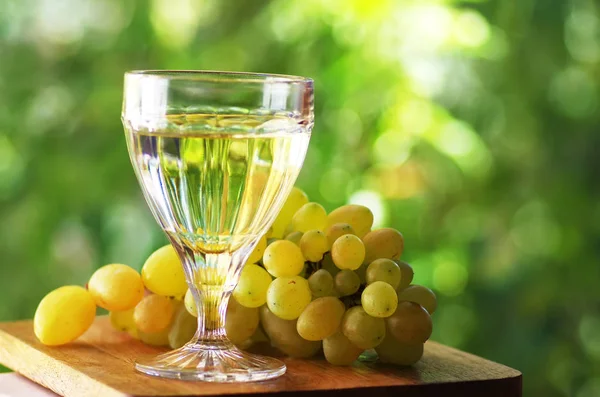 Close-up de vinho com vinho branco sobre fundo verde — Fotografia de Stock