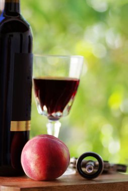 Olgun şeftali masada. Bir bardak kırmızı şarap