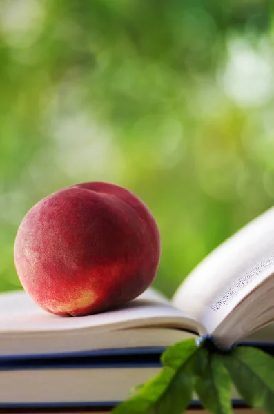 Reifer Pfirsich auf offenem Buch. Nahaufnahme — Stockfoto