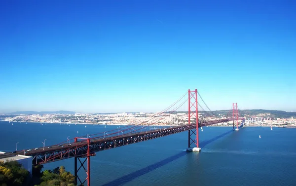 25 kwietnia mostu przez rzekę z Lizbony na tle — Zdjęcie stockowe