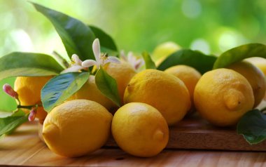 Olgun limon ve ahşap masaya çiçek