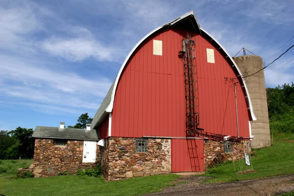 Vintage červená stodola s pole kamenné podezdívce — Stock fotografie