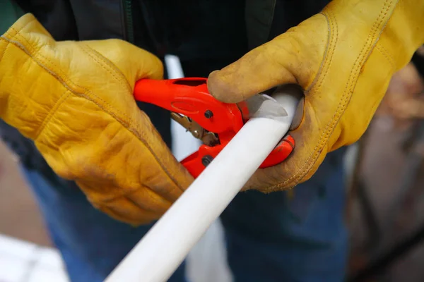 PVC pipe being cut by man — Stock Photo, Image