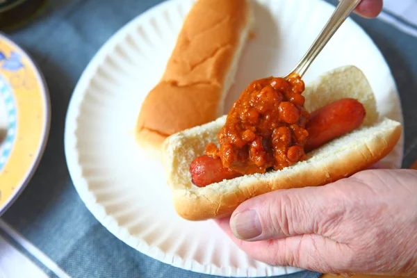 Adicionar chili ao cachorro-quente — Fotografia de Stock