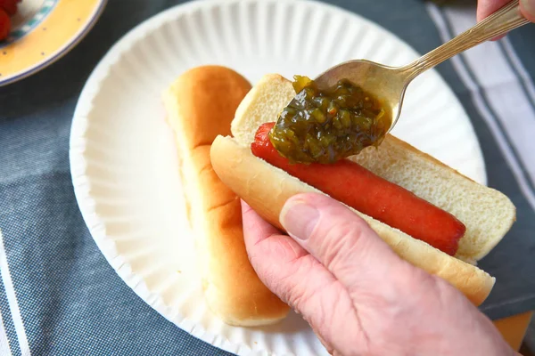 Poner condimento de pepinillo en hot dog —  Fotos de Stock