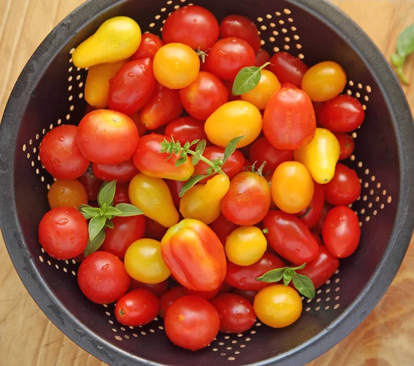 Tomates de cereja em um escorredor escuro — Fotografia de Stock