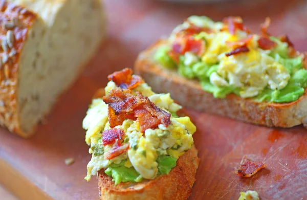 Avocado toast med æg og bacon - Stock-foto