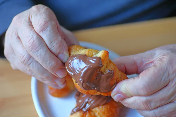 Mann med sjokoladedekt croissant – stockfoto