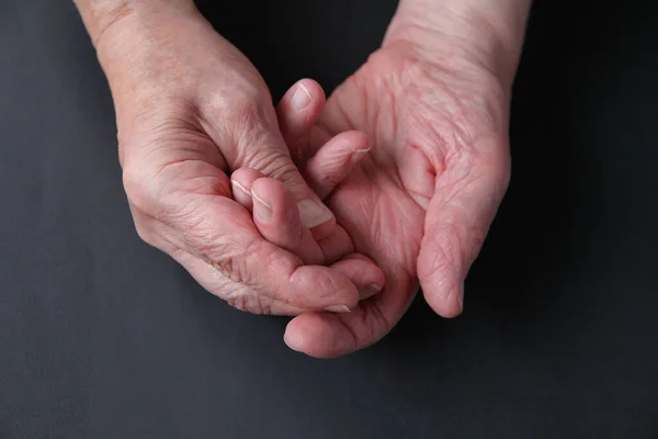 Een Oudere Man Houdt Zijn Pijnlijke Vingers Een Donkere Achtergrond — Stockfoto