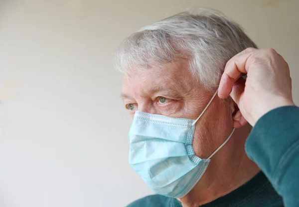Older man with a medical face mask and room for text