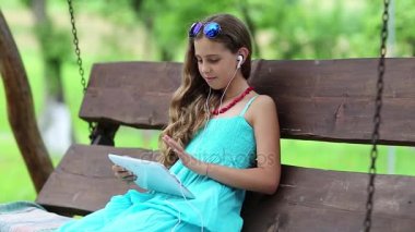 Kız tutan eller tablet içinde oturuyor.  