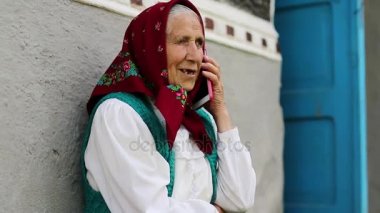 Yaşlı kadın cep telefonuyla konuşuyor