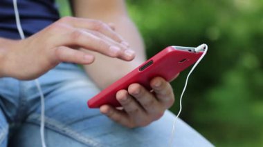Adam kırmızı cep telefonu tutan