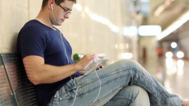 Tablet ile adam bankta oturur