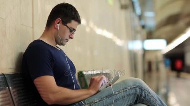 Tablet ile adam bankta oturur 