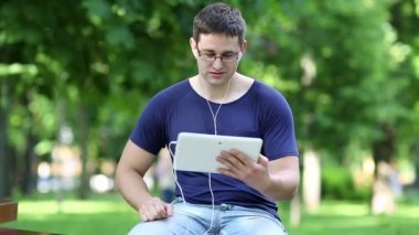 Genç adam tablet ile iletişim kurar. 