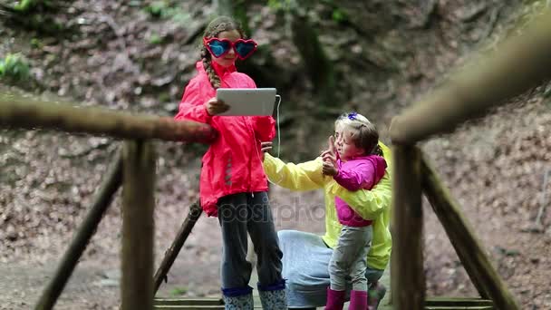 Matka i dwie córki ze smartfonem i tabletem — Wideo stockowe