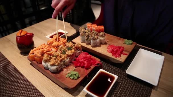 Homem come comida japonesa — Vídeo de Stock