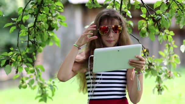 Meisje in zonnebril met witte tablet pc — Stockvideo