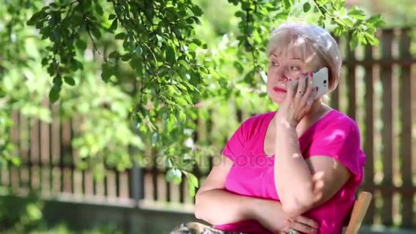 Mujer mayor habla en el teléfono móvil — Vídeos de Stock