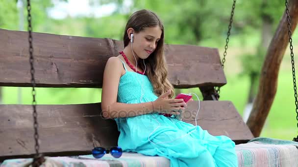 Menina bonita fala com a ajuda do smartphone — Vídeo de Stock