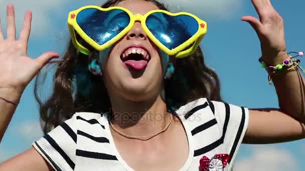 Menina em óculos faz caras engraçadas — Vídeo de Stock