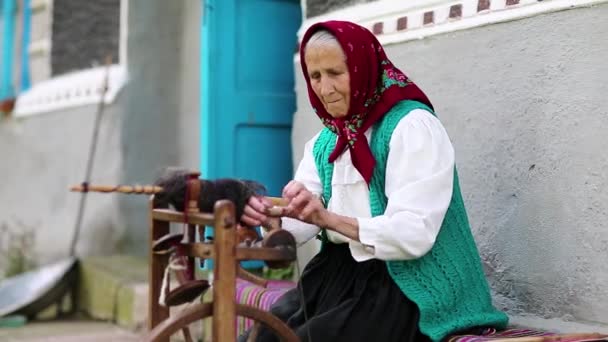Ηλικιωμένη γυναίκα λειτουργεί με ρόκα — Αρχείο Βίντεο