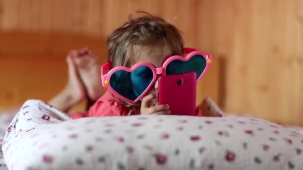 Mädchen mit Smartphone liegt auf Bett