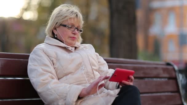 Mujer utiliza teléfono inteligente rojo — Vídeos de Stock