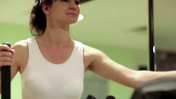 Jonge vrouw op fitnessapparatuur — Stockvideo