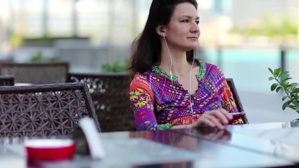 Красива жінка сидить за столом — стокове відео