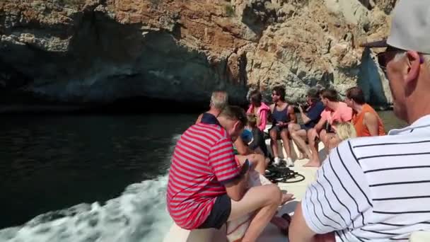 As pessoas flutuam no barco a motor na gruta — Vídeo de Stock