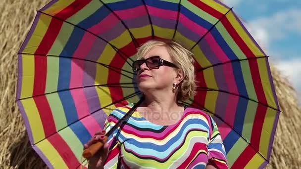 Blonde woman in sunglasses with umbrella — Stock Video