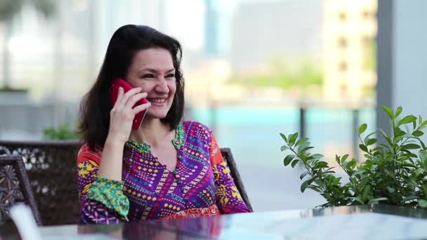 Woman with smartphone sits at table — Stock video