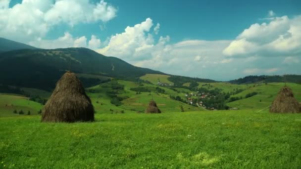4k Timelapse bulutlar ve haystacks güzel yeşil tarlalarda — Stok video