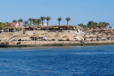 EGYPT, SHARM EL SHEIKH, SINAI, RED SEA, DECEMBER 7, 2019: People on the beach near coast of Red Sea in Sharm El Sheikh, Egypt
