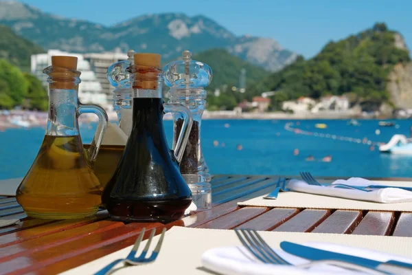 Soy sauce, olive oil, pepper and salt on the table in restaurant with sea view in Montenegro