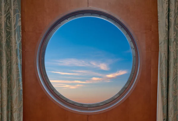 Cielo azul visto a través del ojo de buey de un barco — Foto de Stock