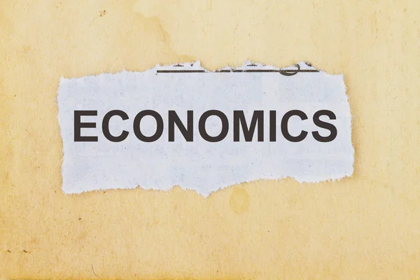 Economics in a cut out newspaper — Stock Photo, Image