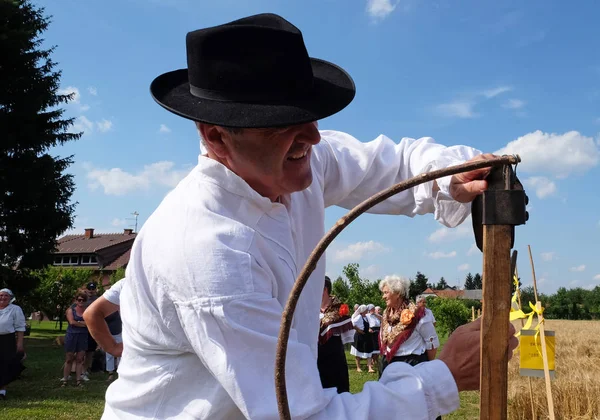 Agricultor afiando a foice no campo em trigo — Fotografia de Stock