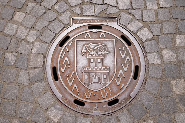 Cubierta de escotilla con el escudo de armas de Liubliana, Eslovenia — Foto de Stock