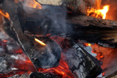 Karanlık bir gecede nehir kenarında kamp ateşi