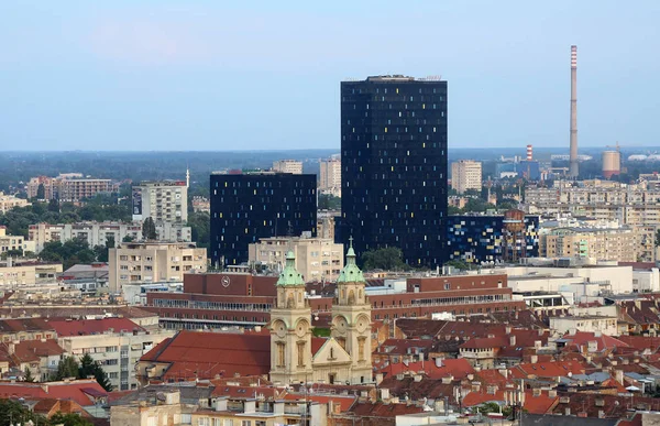 Basílica del Sagrado Corazón de Jesús y los nuevos edificios de oficinas de metal y cristal negro en el centro de la ciudad en el fondo en Zagreb, Croacia — Foto de Stock