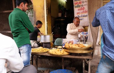 Pushkar Rajasthan, Hindistan 18 Şubat 2016 üzerinde bir sokakta kızarmış sokak gıda satan bir Hint dükkan sahibi.