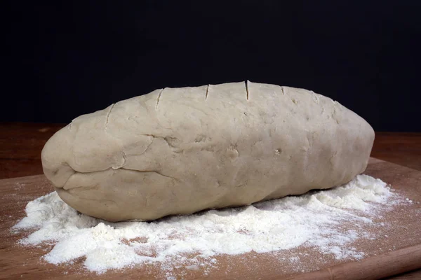 パンを焼きます 生地小麦粉の木製のテーブルの上 — ストック写真