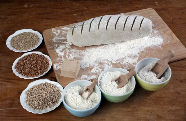 パンを焼きます 生地小麦粉の木製のテーブルの上 — ストック写真