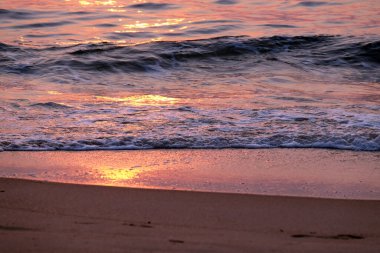 Candolim Sahili, Kuzey Goa, Hindistan 'daki kumların üzerinde dalgalar dönüyor.
