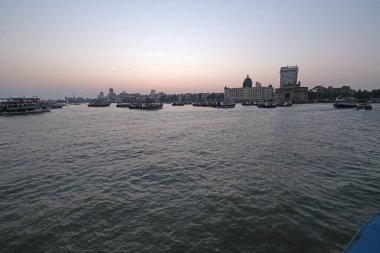 Taj Mahal Oteli, Hindistan Kapısı ve Hindistan 'ın Mumbai şehrinde gün batımında Arap Denizi' nin sularındaki turist tekneleri.