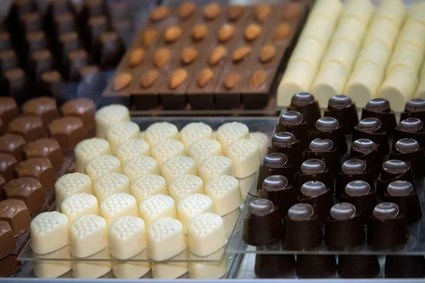 Chocolates feitos à mão de várias formas de coca branca e escura — Fotografia de Stock