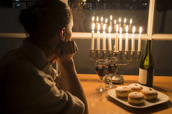 Jewish Girl celebrating hanukkah with menorah and sufganiyah — Stock Photo, Image